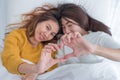Asia lesbian LGBT Couple lay on bed and make heart hand shape wi