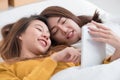 Asia lesbian lgbt couple lying on bed using tablet together in b