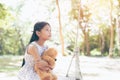 Asia little girl with doll bear sitting on a swing . Royalty Free Stock Photo