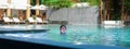 Asia little girl with googles swim in swimming pool in hotel resort beach front in holiday vacation Royalty Free Stock Photo