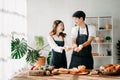 Asia lovers or couples cooking in kitchen with full of ingredient with Bread and fruiton table.Valentines day Royalty Free Stock Photo