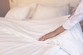 Asia maid making bed in hotel room, setting up pillow on bed Royalty Free Stock Photo