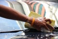 Asia male`s hand holding sponge with foams washing on windscreen by himself