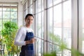 Asia man holding cup coffee and standing near window coffee break time