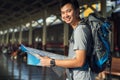 Asia man holding map with bag backpack alone in the train station, preparing,planing and find location for travel trip. Royalty Free Stock Photo