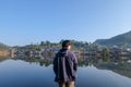 Asia men traveller looking out at village reflection lake standing at ban rak thai Mae Hong Son Thailand