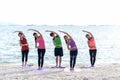 Asia people group making warrior pose on beach, fitness, sport, yoga and healthy lifestyle. Royalty Free Stock Photo