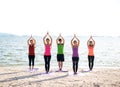 Asia people group making warrior pose on beach, fitness, sport, yoga and healthy lifestyle Royalty Free Stock Photo