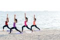 Asia people group making warrior pose on beach, fitness, sport, yoga and healthy lifestyle Royalty Free Stock Photo