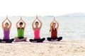 Asia people group making warrior pose on beach, fitness, sport, yoga and healthy lifestyle. Royalty Free Stock Photo