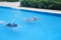 Portrait asia senior woman and caucasian old man resting together in the edge of swimming pool in clubhouse Royalty Free Stock Photo