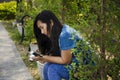 Asia thai woman travel visit and sitting on bench posing for take photo in public garden park Royalty Free Stock Photo