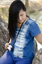 Asia thai woman travel visit and sitting on bench posing for take photo in public garden park Royalty Free Stock Photo