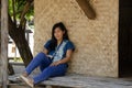 Asia thai woman travel visit and sitting on patio of bamboo and straw hut posing for take photo in Sing Buri, Thailand Royalty Free Stock Photo