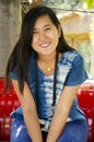 Asia thai woman travel visit and sitting on red metal bench posing for take photo in public garden park Royalty Free Stock Photo