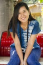 Asia thai woman travel visit and sitting on red metal bench posing for take photo in public garden park Royalty Free Stock Photo