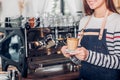 Asia woman barista wear jean apron holding hot coffee cup served Royalty Free Stock Photo