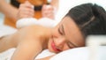 Asia woman lying down on spa bed and receive hot compress treatment in Thai spa on her back. Woman get a therapy massage for full Royalty Free Stock Photo