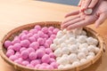 An Asia woman is making Tang yuan, yuan xiao, Chinese traditional food rice dumplings in red and white for lunar new year, winter Royalty Free Stock Photo