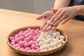 An Asia woman is making Tang yuan, yuan xiao, Chinese traditional food rice dumplings in red and white for lunar new year, winter Royalty Free Stock Photo