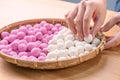 An Asia woman is making Tang yuan, yuan xiao, Chinese traditional food rice dumplings in red and white for lunar new year, winter Royalty Free Stock Photo