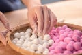 An Asia woman is making Tang yuan, yuan xiao, Chinese traditional food rice dumplings in red and white for lunar new year, winter Royalty Free Stock Photo