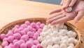 An Asia woman is making Tang yuan, yuan xiao, Chinese traditional food rice dumplings in red and white for lunar new year, winter Royalty Free Stock Photo