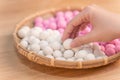 An Asia woman is making Tang yuan, yuan xiao, Chinese traditional food rice dumplings in red and white for lunar new year, winter Royalty Free Stock Photo