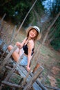 Asia woman in summer fashion sitting on bamboo bridge