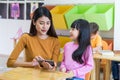 Asia woman teacher teach girl student with tablet computer in cl Royalty Free Stock Photo