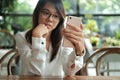 Asia woman using mobile phone with front camera for selfie and s