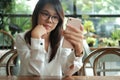 Asia woman using mobile phone with front camera for selfie and s