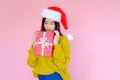 asia woman wearing long sleeve clothes on pink background with gift box in hand, Christmas or X\'mas and happy new year Royalty Free Stock Photo