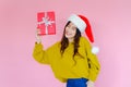 asia woman wearing long sleeve clothes on pink background with gift box in hand, Christmas or X'mas and happy new year Royalty Free Stock Photo