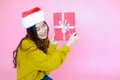 asia woman wearing long sleeve clothes on pink background with gift box in hand, Christmas or X\'mas and happy new year Royalty Free Stock Photo