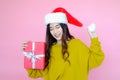 asia woman wearing long sleeve clothes on pink background with gift box in hand, Christmas or X\'mas and happy new year Royalty Free Stock Photo