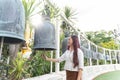 Asia woman wearing traditional dress of Thailand chime for happiness at Wat Saket Ratcha Wora Maha Wihan