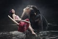 Asia Woman wearing traditional style costume sitting and posing with big elephant in the river Royalty Free Stock Photo