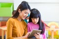 Asia woman teacher teach girl student with tablet computer in cl Royalty Free Stock Photo