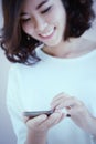 Asia Young beautiful woman writes SMS to mobile phone Royalty Free Stock Photo