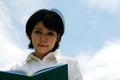 Asia young woman reading and holding book on sky background. Royalty Free Stock Photo