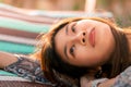 Woman lying on Beach Bed sun bathing with eye open to the sky, for summer relaxation concept
