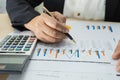 Asian accountant working and analyzing financial reports project accounting with chart graph and calculator in modern office Royalty Free Stock Photo