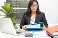 Asian accountant working and analyzing financial reports project accounting with chart graph and calculator in modern office, Royalty Free Stock Photo