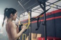 Asian active athlete girl straight out her arms to hold rope anchored to a steel beam in stadium. Sportswoman Lifting up and down Royalty Free Stock Photo