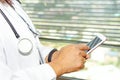 Asian active woman lady holding mobile phone to communicate about work at hospital. Royalty Free Stock Photo