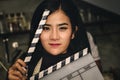 Asian actress holding slate film and expressing emotion to test