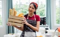 Asian adorable pretty beautiful woman smiling with happiness, holding and showing wooden basket of baked bread while staying at Royalty Free Stock Photo