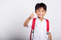 Asian adorable toddler smiling happy wearing student thai uniform red pants show thumb up finger Royalty Free Stock Photo