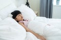Asian adorable young kid daughter sleeping on bed in bedroom at home. Little preschool napping girl child close eyes, put on Royalty Free Stock Photo